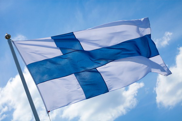 Suomen lippu liehuu tuulessa kauniina päivänä liputuspäivä